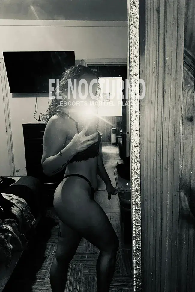Escort Pia rulitos de Mar del Plata, parada de perfil mostrando la cola